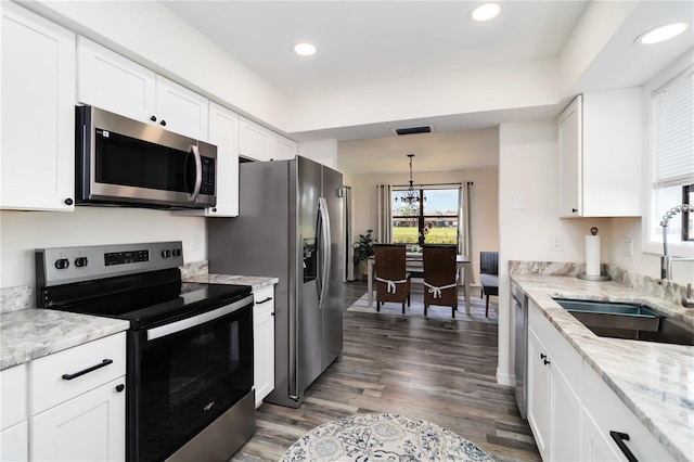 1439 Strada D Argento, Venice, FL 34292 - kitchen with stainless steel appliances, a chandelier, white cabinetry, dark wood-style floors, and recessed lighting