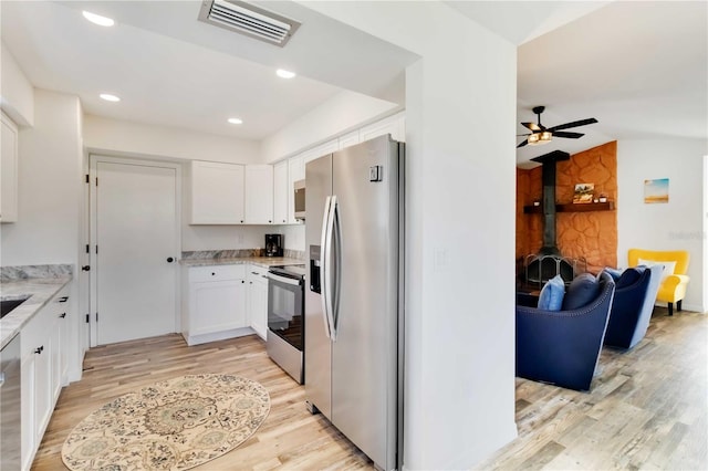 1439 Strada D Argento, Venice, FL 34292 - kitchen featuring stainless steel appliances, light wood-style floors, white cabinets, light stone countertops, and lofted ceiling