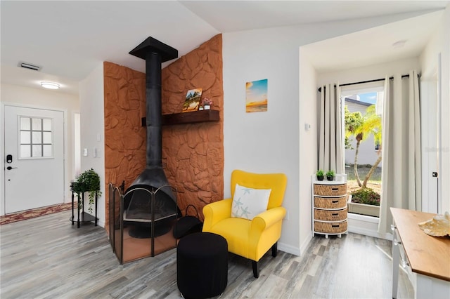 1439 Strada D Argento, Venice, FL 34292 - living area with light wood-style flooring, a wood stove, and vaulted ceiling