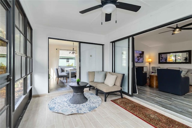 1439 Strada D Argento, Venice, FL 34292 - living area featuring a ceiling fan, light wood finished floors, a chandelier, and ornamental molding