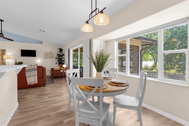 2424 Affinity Ln, North Port, FL 34286 - dining room featuring plenty of natural light, vaulted ceiling, light wood finished floors, and baseboards
