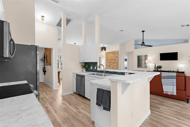 2424 Affinity Ln, North Port, FL 34286 - kitchen with appliances with stainless steel finishes, a peninsula, lofted ceiling, white cabinetry, and a ceiling fan