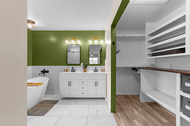 2424 Affinity Ln, North Port, FL 34286 - full bath featuring a soaking tub, double vanity, wainscoting, tile walls, and marble look tile flooring