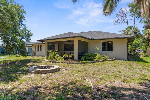 2424 Affinity Ln, North Port, FL 34286 - rear view of property featuring a fire pit, a ceiling fan, a lawn, and stucco siding