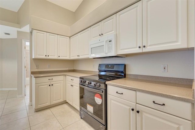 3851 Sterling Rd, Venice, FL 34293 - kitchen with white microwave, electric range, light countertops, and light tile patterned floors