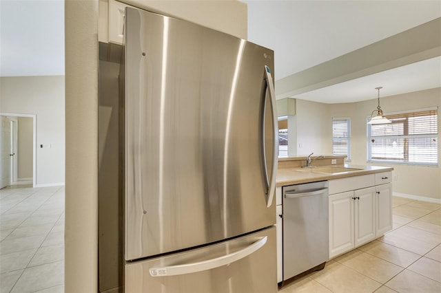 3851 Sterling Rd, Venice, FL 34293 - kitchen featuring appliances with stainless steel finishes, a sink, light tile patterned floors, and white cabinets