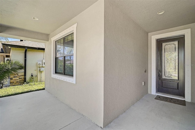 doorway to property featuring stucco siding