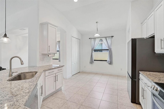 kitchen with a sink, appliances with stainless steel finishes, light stone countertops, pendant lighting, and white cabinets