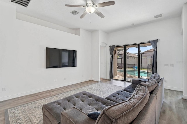 living room featuring a ceiling fan, wood finished floors, and baseboards
