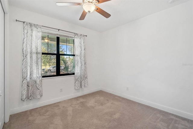 spare room with carpet flooring, baseboards, and ceiling fan