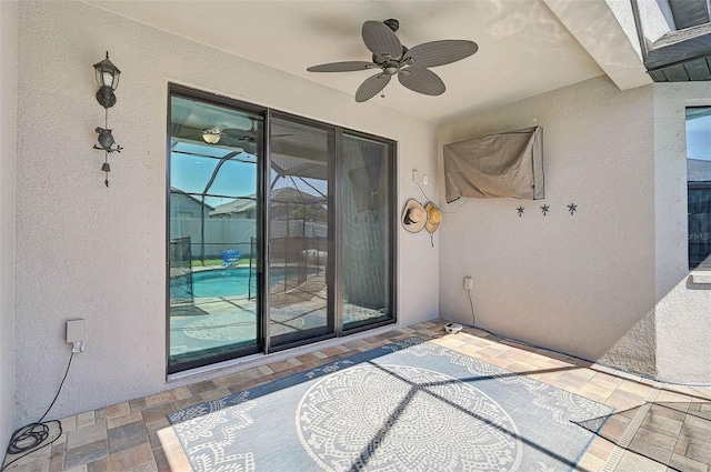 property entrance featuring stucco siding and a ceiling fan