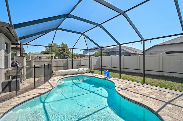view of pool with a patio, a fenced backyard, and a lanai