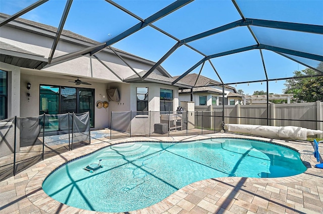 view of pool featuring a patio area, ceiling fan, fence, and glass enclosure
