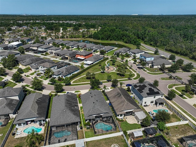 aerial overview of property's location with a pool area, a heavily wooded area, and nearby suburban area