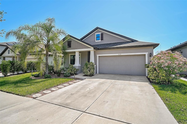 view of front of property featuring an attached garage, concrete driveway, stucco siding, a front lawn, and a shingled roof