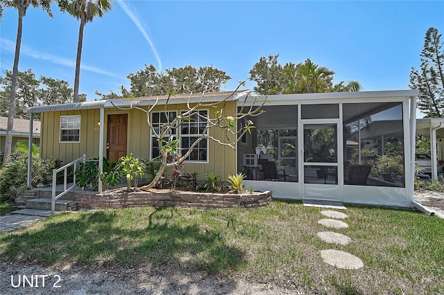 417 Shore Rd Unit A & B, Nokomis, FL 34275 - view of front of house with a sunroom, a front lawn, and board and batten siding