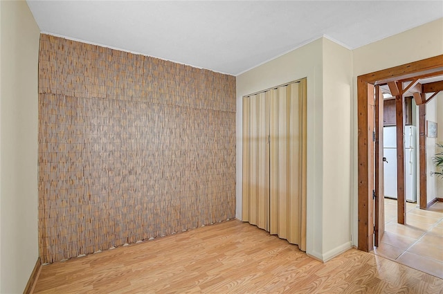 417 Shore Rd Unit A & B, Nokomis, FL 34275 - empty room with light wood finished floors, ornamental molding, tile walls, and baseboards