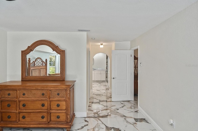 27416 Natal Dr, Punta Gorda, FL 33983 - hall featuring baseboards, arched walkways, and light marble finish floors