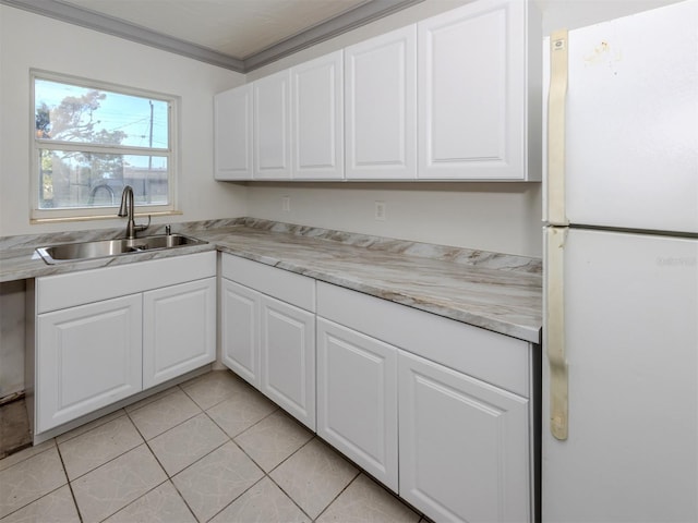 6231 Jordan St, North Port, FL 34287 - kitchen featuring freestanding refrigerator, a sink, white cabinets, light countertops, and light tile patterned floors