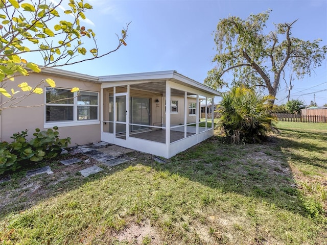 6231 Jordan St, North Port, FL 34287 - rear view of house featuring a sunroom and stucco siding
