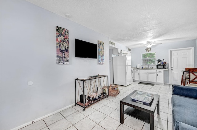 422 Polk Ave, Cape Canaveral, FL 32920 - living area with a textured ceiling, light tile patterned floors, a ceiling fan, and baseboards