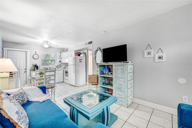 422 Polk Ave, Cape Canaveral, FL 32920 - living area featuring a ceiling fan, light tile patterned floors, baseboards, and a textured ceiling