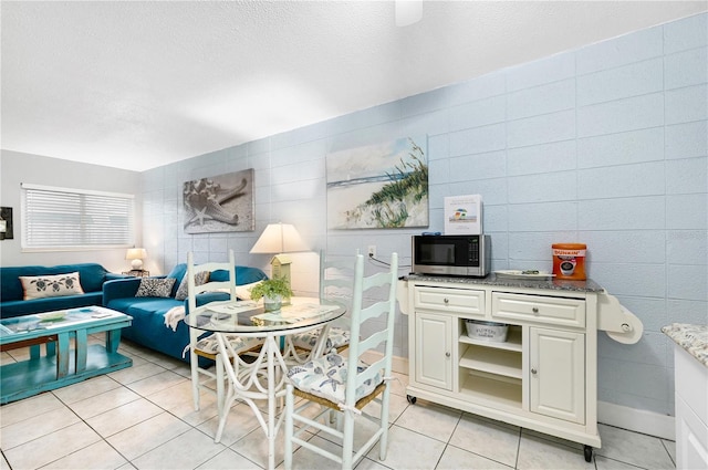 422 Polk Ave, Cape Canaveral, FL 32920 - living area with light tile patterned floors, tile walls, a textured ceiling, and breakfast area