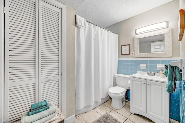 422 Polk Ave, Cape Canaveral, FL 32920 - full bathroom with tile patterned flooring, toilet, tile walls, vanity, and wainscoting