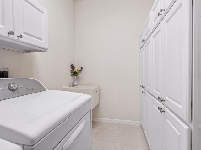 1493 Maseno Dr, Venice, FL 34292 - laundry area with washer / clothes dryer, cabinet space, baseboards, and light tile patterned floors