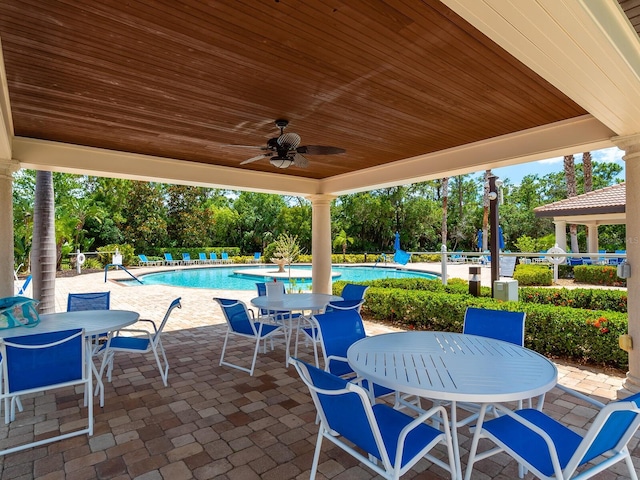 1493 Maseno Dr, Venice, FL 34292 - view of patio / terrace with outdoor dining space, a community pool, ceiling fan, and view of wooded area