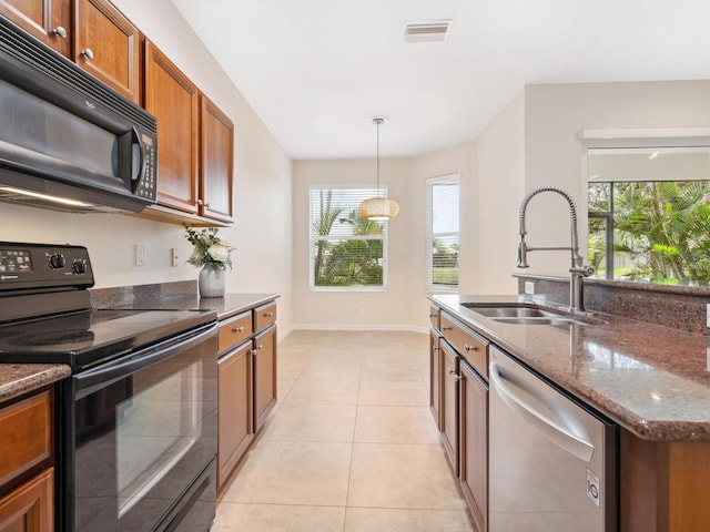 1493 Maseno Dr, Venice, FL 34292 - kitchen featuring black appliances, a sink, brown cabinets, dark stone counters, and baseboards