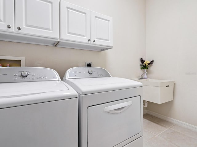 1493 Maseno Dr, Venice, FL 34292 - laundry room with washing machine and dryer, cabinet space, light tile patterned flooring, and baseboards