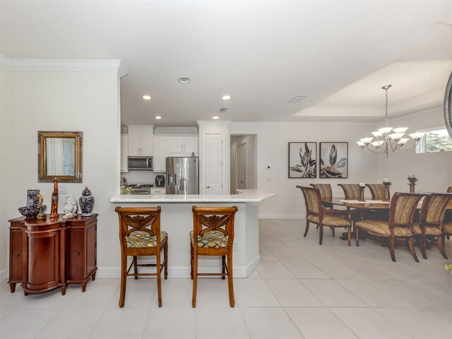 5853 Semolino St, Nokomis, FL 34275 - kitchen with stainless steel appliances, recessed lighting, a peninsula, ornamental molding, and a chandelier