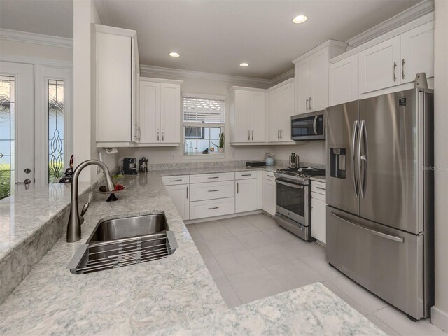 5853 Semolino St, Nokomis, FL 34275 - kitchen featuring appliances with stainless steel finishes, crown molding, a sink, white cabinets, and light stone counters