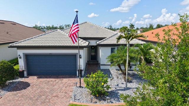 1481 Hyssop Loop, North Port, FL 34289 - view of front facade featuring a tiled roof, an attached garage, stucco siding, and decorative driveway