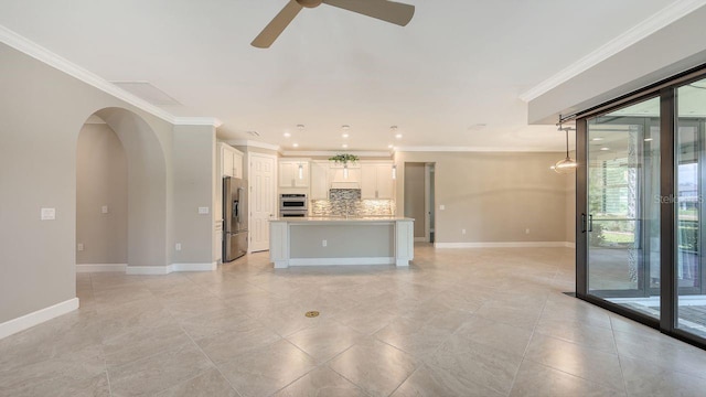 1481 Hyssop Loop, North Port, FL 34289 - unfurnished living room with a ceiling fan, ornamental molding, baseboards, arched walkways, and light tile patterned floors
