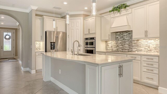 1481 Hyssop Loop, North Port, FL 34289 - kitchen with appliances with stainless steel finishes, custom exhaust hood, a sink, light tile patterned floors, and tasteful backsplash