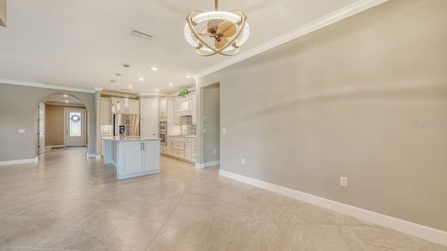 1481 Hyssop Loop, North Port, FL 34289 - kitchen featuring stainless steel appliances, ornamental molding, arched walkways, backsplash, and light countertops
