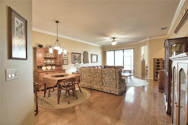 1438 Maseno Dr, Venice, FL 34292 - dining room featuring wood finished floors, ceiling fan, crown molding, a textured wall, and baseboards