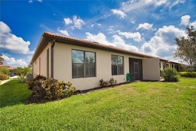 1438 Maseno Dr, Venice, FL 34292 - back of house with stucco siding, a lawn, central air condition unit, and a tile roof
