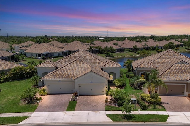 21649 Avon Park Ct, Venice, FL 34293 - mediterranean / spanish-style house with a tiled roof, decorative driveway, a garage, and a residential view