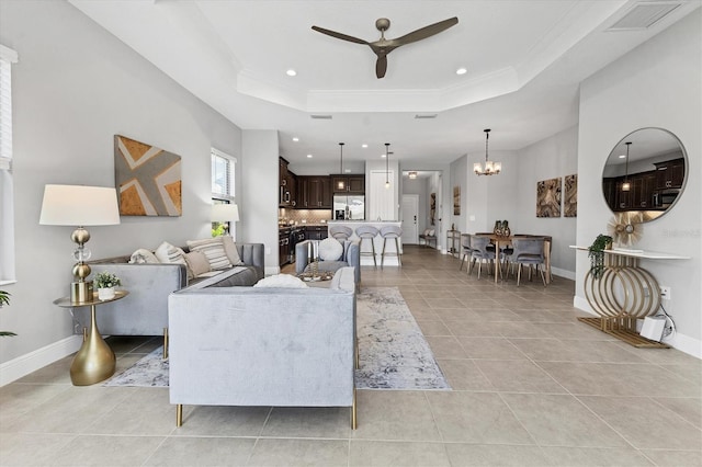 21649 Avon Park Ct, Venice, FL 34293 - living room with ceiling fan, a tray ceiling, recessed lighting, light tile patterned floors, and a chandelier