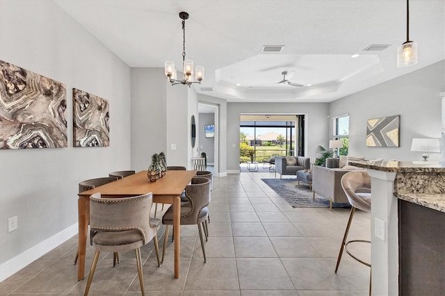 21649 Avon Park Ct, Venice, FL 34293 - dining room featuring a tray ceiling, ceiling fan, light tile patterned flooring, and a chandelier