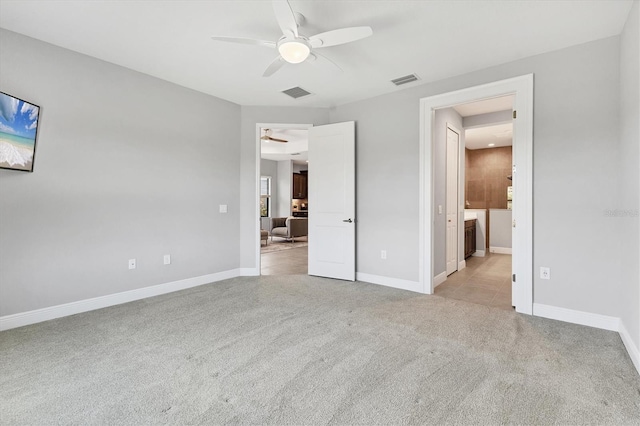 21649 Avon Park Ct, Venice, FL 34293 - unfurnished bedroom with light carpet, baseboards, ensuite bath, and a ceiling fan