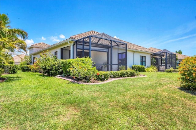21649 Avon Park Ct, Venice, FL 34293 - back of property with a tile roof, a lawn, stucco siding, and a lanai