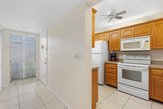 458 Cerromar Rd Unit 382, Venice, FL 34293 - kitchen with white appliances, light tile patterned flooring, light countertops, ceiling fan, and baseboards