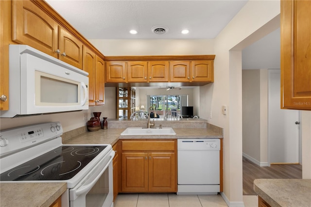 458 Cerromar Rd Unit 382, Venice, FL 34293 - kitchen with white appliances, a sink, light countertops, brown cabinetry, and recessed lighting
