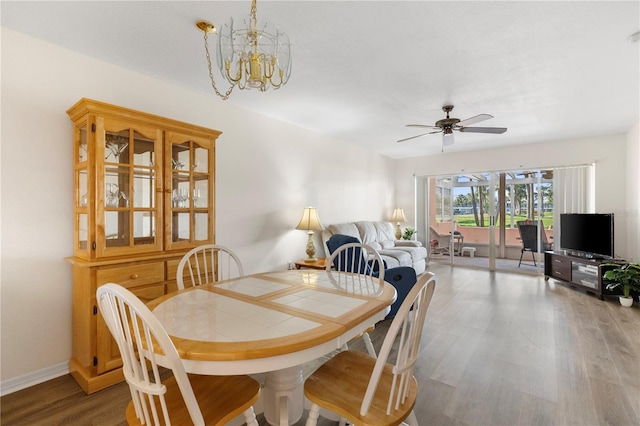 458 Cerromar Rd Unit 382, Venice, FL 34293 - dining room with wood finished floors, a ceiling fan, a chandelier, and baseboards