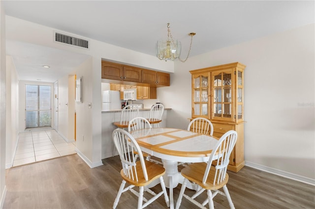 458 Cerromar Rd Unit 382, Venice, FL 34293 - dining space with baseboards, light wood-style floors, and a chandelier