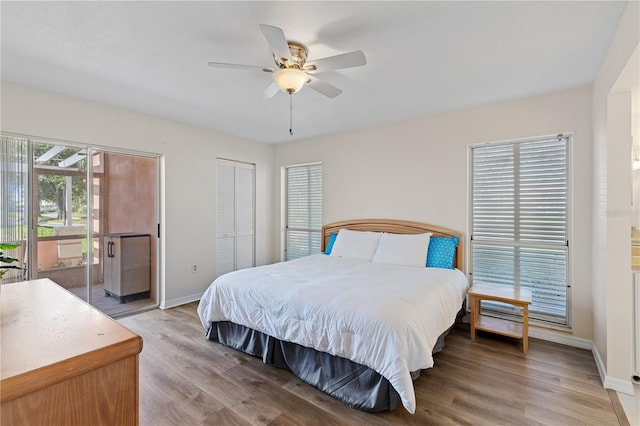 458 Cerromar Rd Unit 382, Venice, FL 34293 - bedroom with baseboards, light wood-style flooring, access to exterior, ceiling fan, and two closets